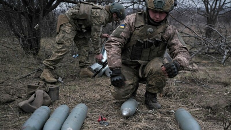 Ukrainische Soldaten bei der Vorbereitung von Artilleriegranaten (Bild: APA/AFP/Sergey SHESTAK)