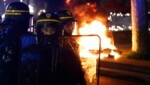 Bereitschaftspolizisten stehen neben einem Feuer, das von Demonstranten während einer Demonstration auf dem Place de la République gelegt wurde, wenige Tage nachdem die Regierung eine Pensionsreform ohne Abstimmung durch das Parlament gebracht hatte. (Bild: APA/AFP/Ludovic MARIN)