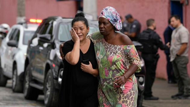 Die Mutter einer überlebenden Lehrerin weint vor Erleichterin. (Bild: Associated Press)