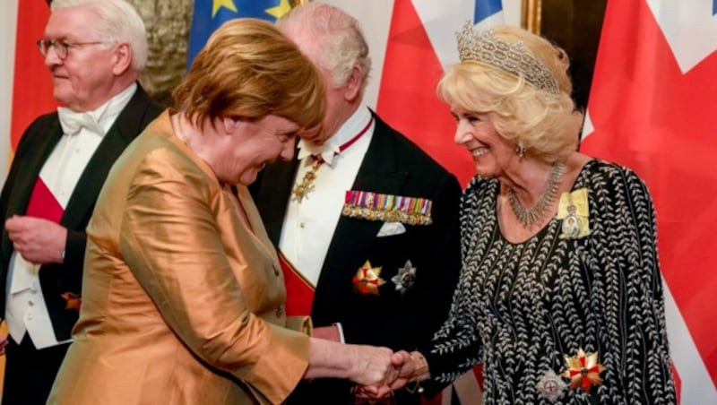 Königsgemahlin Camilla schüttelte Deutschlands Altkanzlerin Angela Merkel freudestrahlend die Hand. (Bild: APA/AFP/POOL/Matthias Schrader)