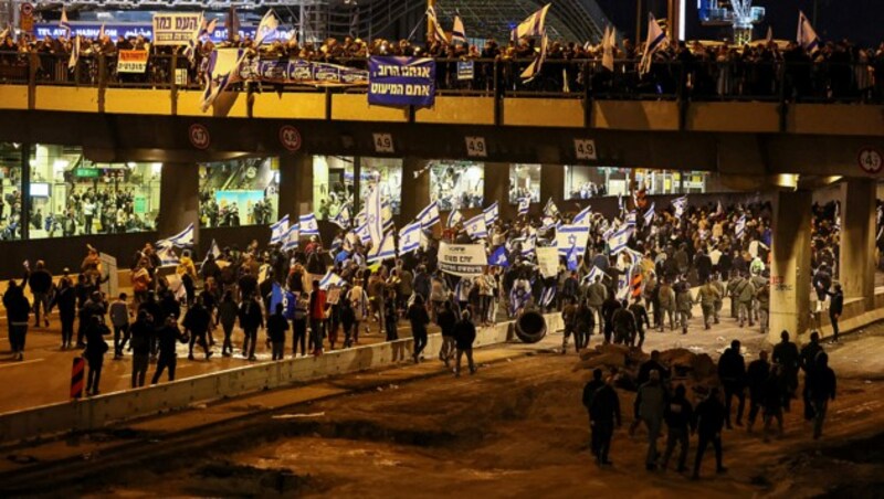 Anhänger des israelischen Ministerpräsidenten Benjamin Netanyahu blockieren eine Autobahn in Tel Aviv. (Bild: APA/AFP/JACK GUEZ)