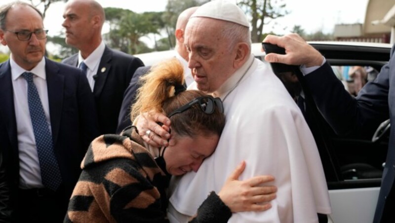 Beim Verlassen des Krankenhauses umarmte Papst Franziskus ein Ehepaar, das in der Nacht auf Sonntag seine Tochter verloren hat. (Bild: AP)