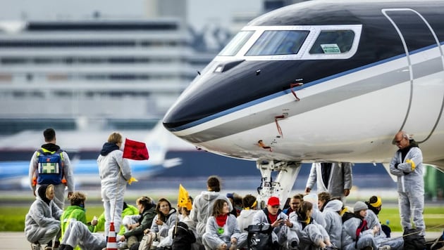 Im November ketteten sich Klimaaktivisten in Amsterdam an Privatjets. Nun verbietet der Airport diese ab Ende 2025. (Bild: AFP)
