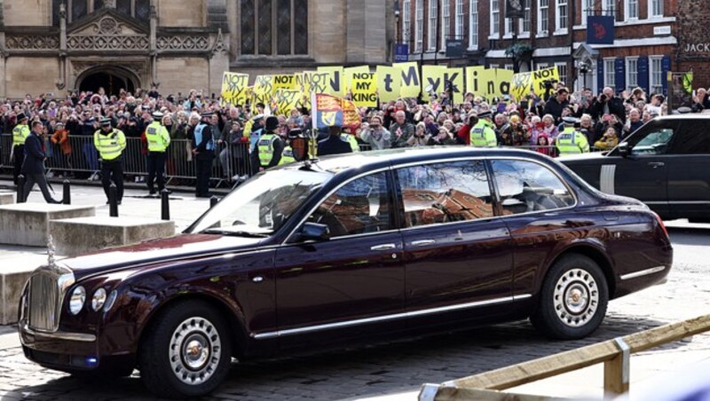 Bei der Ankunft vor der York Minster hielten Demonstranten Schilder mit den Worten „Not My King“ in die Höhe. Charles und Camilla ließen sich davon aber nicht die gute Laune verderben. (Bild: APA/AFP/Darren Staples)