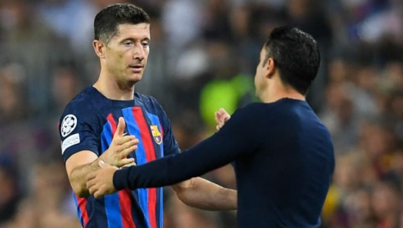 Robert Lewandowski klatscht bei seiner Auswechslung mit Trainer Xavi Hernandez ab. (Bild: APA/AFP/Pau BARRENA)