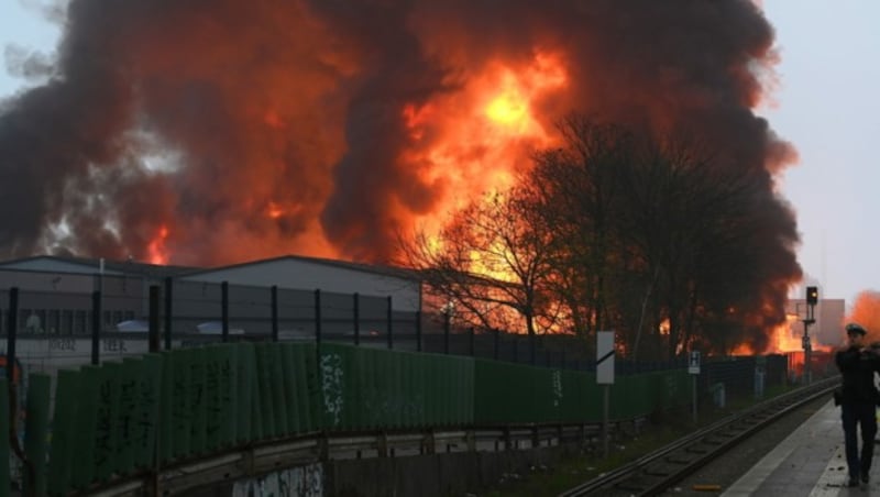 Zwei Lagerhallen stehen seit Sonntagfrüh in Hamburg in Flammen. Aufgrund starker Rauch- und Gasentwicklung, mit möglicher chemischer Bestandteile, hat die örtliche Polizei eine amtliche Gefahrenmeldung herausgegeben. (Bild: APA/dpa/Jonas Walzberg)