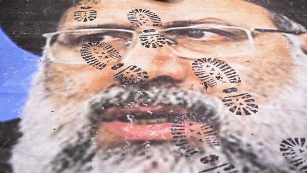 Ein Demonstrant tritt auf ein Plakat, das den iranischen Präsidenten Ebrahim Raisi zeigt. (Bild: AFP)