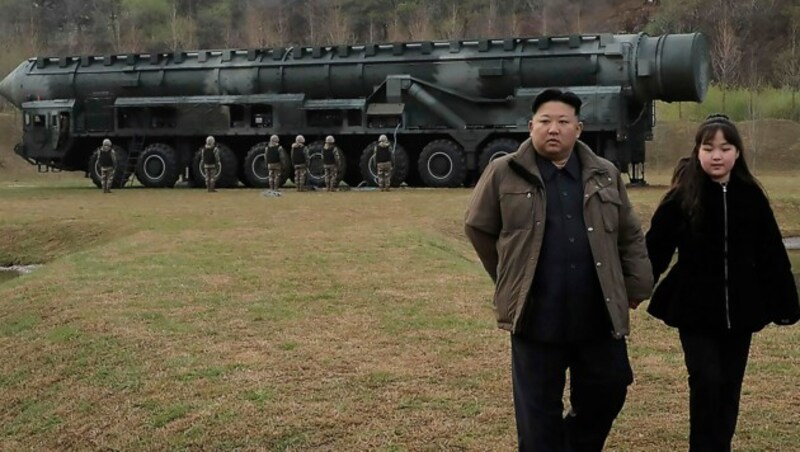 Machthaber Kim Jong Un und seine Tochter, im Hintergrund die neue Langstreckenrakete Hwasong-18 (Bild: AP)