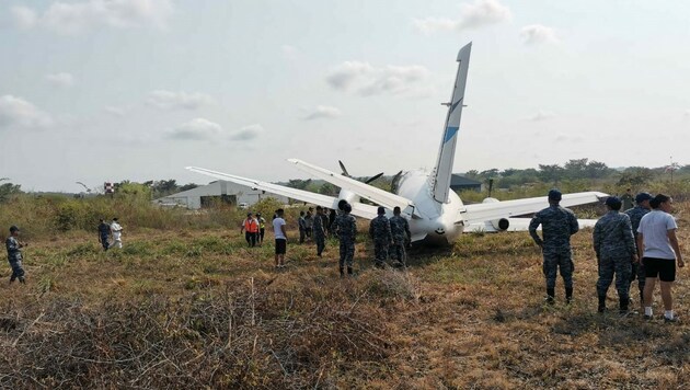 Ein von der Armee veröffentlichtes Foto zeigt die Maschine des Flugzeugbauers Saab neben der Landebahn im Gras stehend, ein abgebrochenes Flugzeugteil liegt auf der Landebahn. (Bild: AFP)