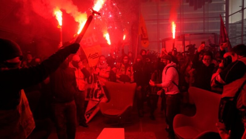 Demonstranten mit Fackeln stürmen das Gebäude der Euronext in Paris. (Bild: AP)