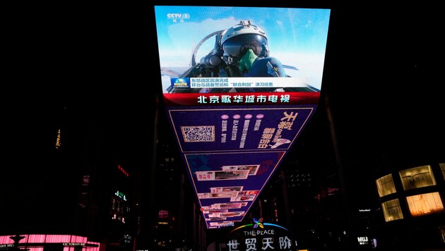 Auf einem Screen in Peking ist ein chinesischer Kampfjetpilot zu sehen, der bei der kürzlich abgeschlossenen Joint Sword-Übung in der Nähe von Taiwan den Daumen nach oben zeigt. (Bild: AP)