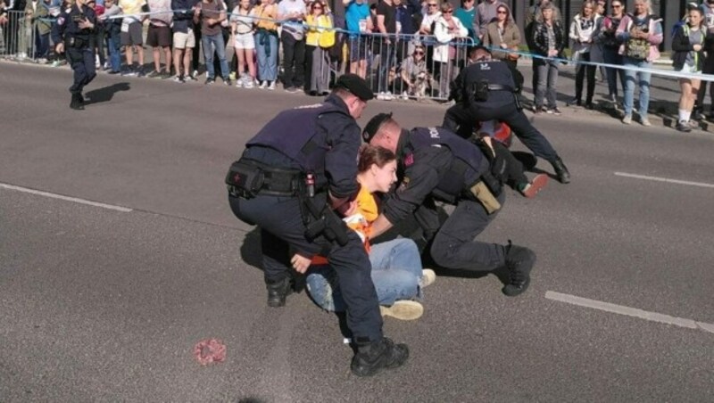 Aktivisten klebten sich auf die Laufstrecke. Die Polizei stand sofort im Einsatz. (Bild: Letzte Generation AT)