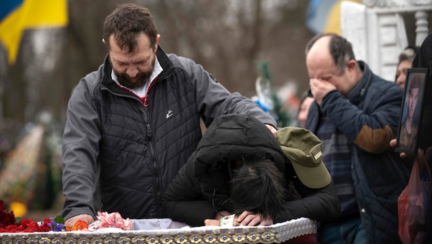 Eltern eines gefallenen ukrainischen Soldaten trauern am Sarg ihres Sohnes in der Region Luhansk. (Bild: AP)