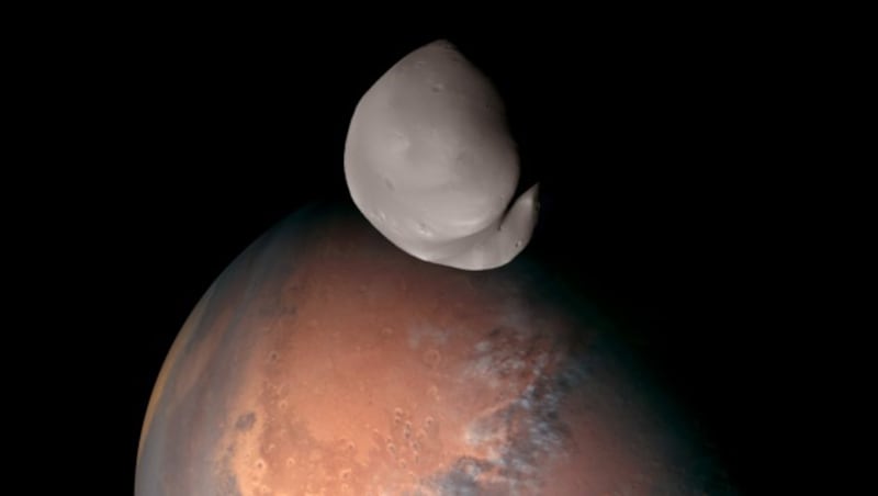 Der Marsmond Deimos (Bildmitte oben) in seinem Orbit um den Roten Planeten (Bild: APA/AFP/Emirates Mars Mission)