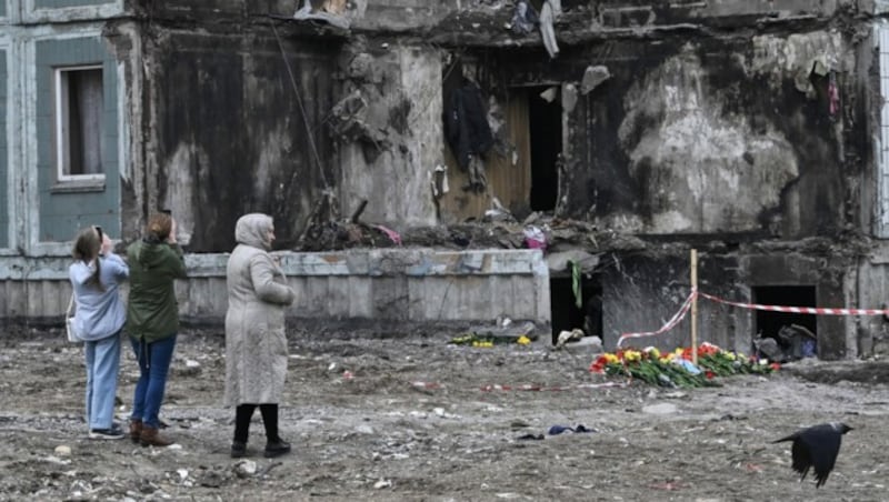 Die ukrainische Bevölkerung vor einem zerstörten Wohnhaus (Bild: AFP/Genya Savilov/)