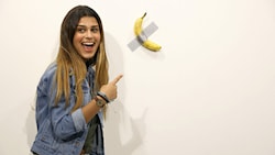 Maurizio Cattelans Kunstwerk „Comedian“ - eine an die Wand geklebte Banane - bei der Art Basel in Miami. (Bild: APA/Cindy Ord/Getty Images/AFP )