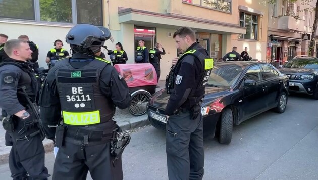 Polizisten stehen vor der Schule in Neukölln. Zwei Schulkinder wurden am Mittwoch von einem Mann niedergestochen. (Bild: APA/dpa/Michael Kappeler)