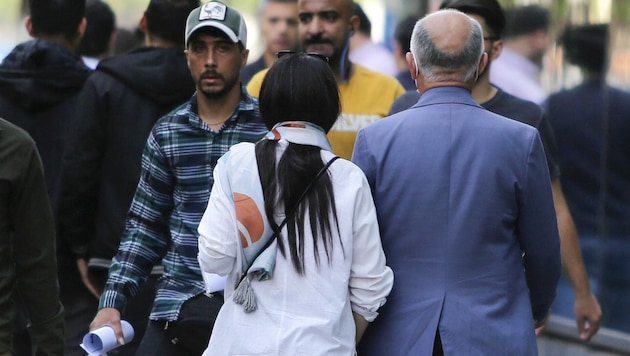 Eine Frau im Iran hat ihr Kopftuch lose um den Hals gebunden. (Bild: ATTA KENARE / AFP)