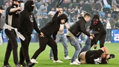 Die „Fans“ prügeln mit Gürteln aufeinander ein. (Bild: APA/AFP/Tiziana FABI)