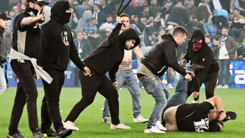 Die „Fans“ prügeln mit Gürteln aufeinander ein. (Bild: APA/AFP/Tiziana FABI)