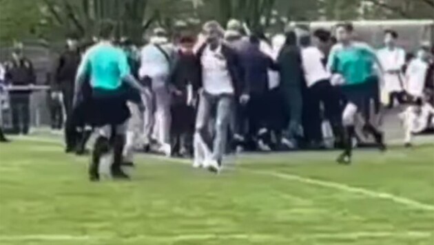 Unfassbar: Der Mann (Mitte, weißes T-Shirt, weiße Schuhe) attackiert den 15-jährigen Schiedsrichter (li.). (Bild: schiedsrichter_frankfurt/Instagram)