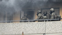 Spezialkräfte der Polizei betreten inmitten von Rauch die Hochhauswohnung, nachdem es dort zu einer Explosion gekommen war. (Bild: AFP)