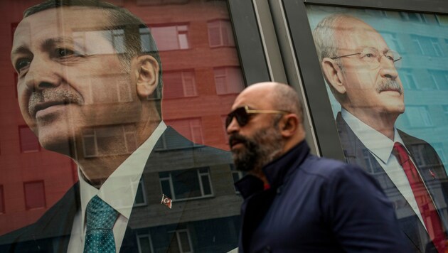 Ein Passant spaziert an Plakaten des amtierenden Präsidenten Recep Tayyip Erdogan (li.) und seinem Herausforderer Kemal Kilicdaroglu (re.) vorbei. (Bild: Associated Press)