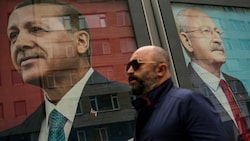 Ein Passant spaziert an Plakaten des amtierenden Präsidenten Recep Tayyip Erdogan (li.) und seinem Herausforderer Kemal Kilicdaroglu (re.) vorbei. (Bild: Associated Press)