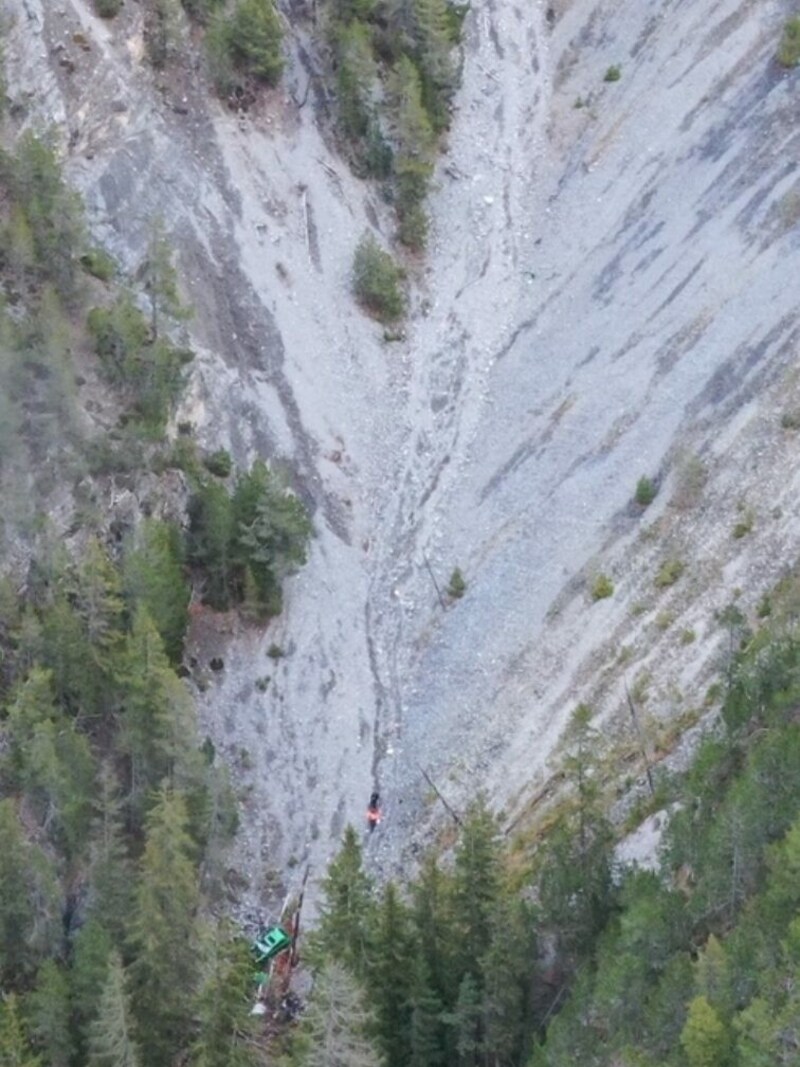 Das Wrack des grünen Pkws kam in der schwer zugänglichen Schlucht zum Liegen. (Bild: KAPO Graubünden)