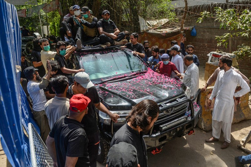Anhänger schwärmen Khans Auto, als dieser seine Residenz verlässt, um vor Gericht zu erscheinen. (Bild: AFP)