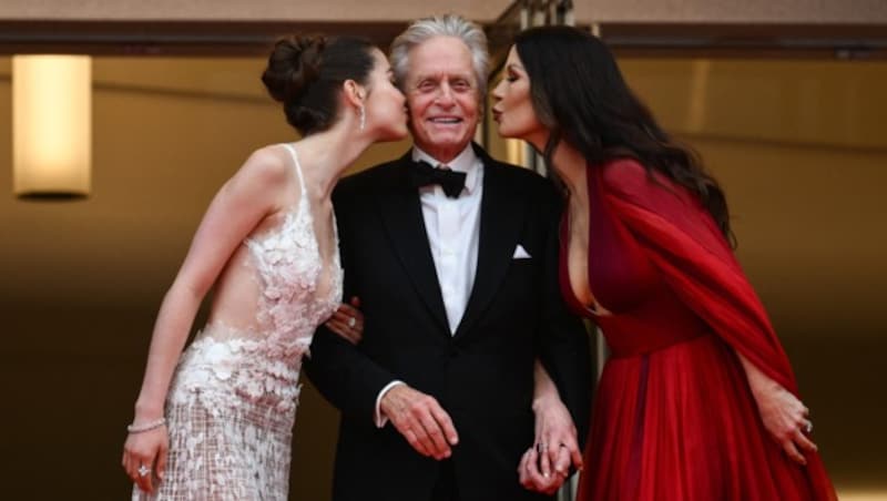 Ein Bussi für Michael Douglas: Carys Zeta Douglas und Catherine-Zeta Jones überstrahlten bei der Eröffnung der Filmfestspiele von Cannes alle. (Bild: APA/AFP/CHRISTOPHE SIMON)