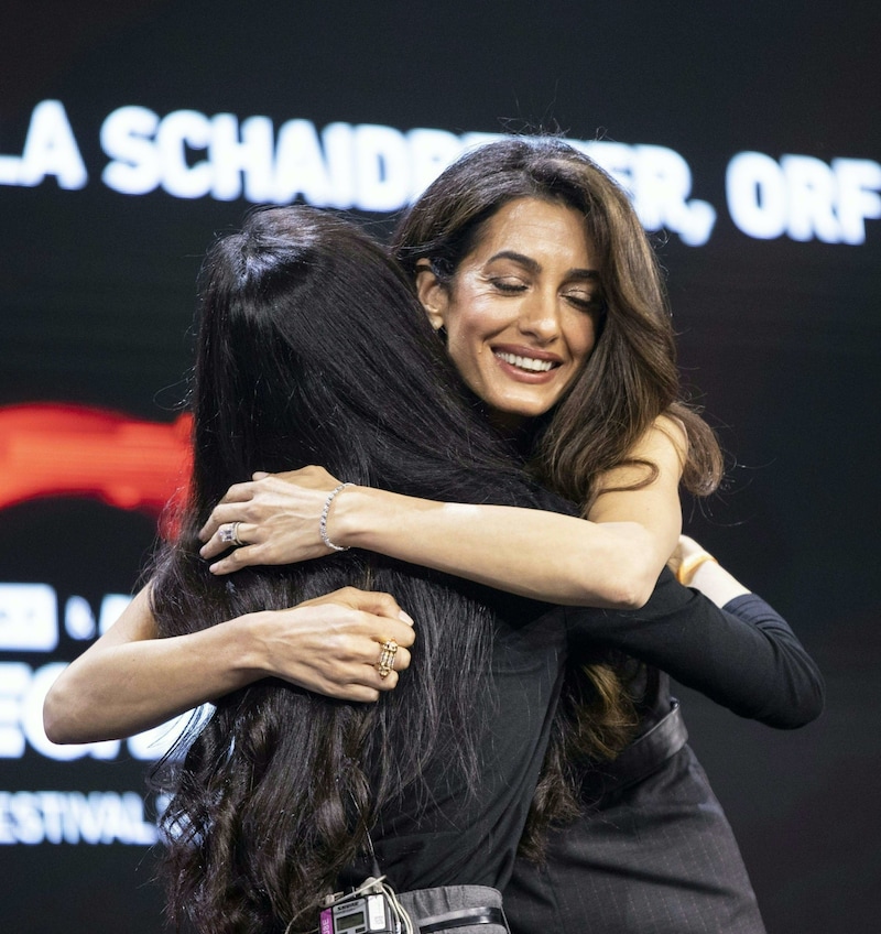 Clooney umarmt ihre Klientin und Friedensnobelpreisträgerin Nadia Murad, die auch am Festival sprach. (Bild: APA/TOBIAS STEINMAURER)