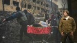 „World Press Photo“-Sieger Evgeniy Maloletka vor seinem Gewinnerfoto, das die Schrecken des Krieges in der Ukraine anhand eines Einzelschicksals zeigt. (Bild: imago / ANP / Ramon van Flymen)