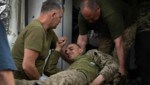 Ein verwundeter Soldat in der ostukrainischen Frontstadt Bachmut wird von Kameraden versorgt. (Bild: AP)