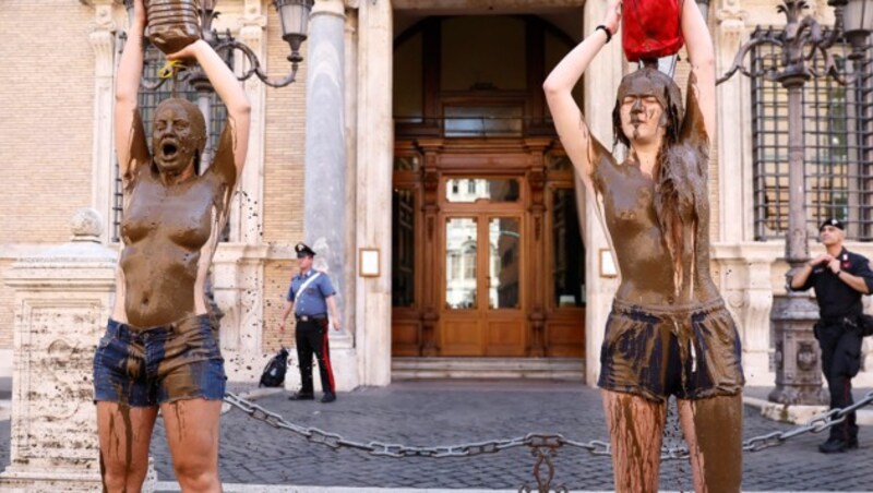 Klimaaktivisten der Gruppe Ultima Generazione (Letzte Generation) hatten sich am Dienstag vor einem Parlamentsgebäude in Rom mit Schlamm übergossen und damit auf die Überschwemmungen in Italien als Folge des Klimawandels hingewiesen. (Bild: AP)