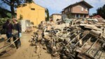 Freiwillige beseitigen Schlamm, während Haushaltsgegenstände am Straßenrand in Faenza - in der vom Hochwasser betroffenen Region Emilia Romagna - liegen. (Bild: AP)