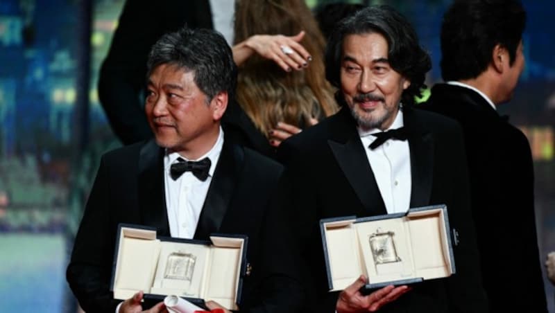 Regissuer Hirokazu Koreeda (li.) und Schauspieler Koji Yakusho posieren mit ihren Preisen für die Kameras. (Bild: APA/AFP/CHRISTOPHE SIMON)