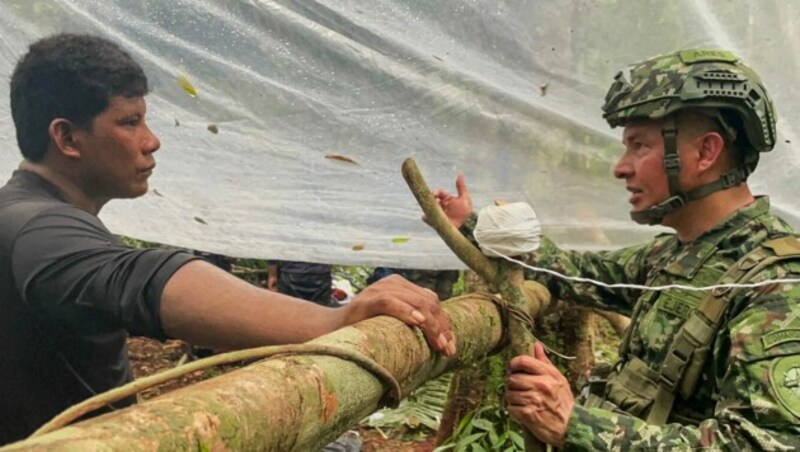 Der Vater der Kinder spricht mit einem der Einsatzkräfte (Bild: AFP)