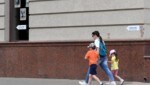 Eine Frau geht mit ihren Kindern an einem Schild mit der Aufschrift „Schutzbunker“ in der russischen Stadt Belgorod vorbei. (Bild: AFP)