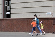Eine Frau geht mit ihren Kindern an einem Schild mit der Aufschrift „Schutzbunker“ in der russischen Stadt Belgorod vorbei. (Bild: AFP)