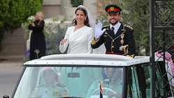 Kronprinz Hussein und seine Frau Saudi Rajwa al-Seif winken, als sie nach ihrer Hochzeitszeremonie den Zahran-Palast in Amman verlassen. (Bild: APA/AFP/Khalil MAZRAAWI)