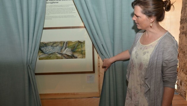 Edith Hessenberger enthüllt den „Star“ der Ausstellung: die weltweit älteste Gletscherdarstellung. (Bild: Daum Hubert)