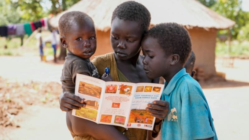 Kinder im Sudan lesen eine Broschüre über die Gefahren von Landminen. (Bild: ASSOCIATED PRESS)