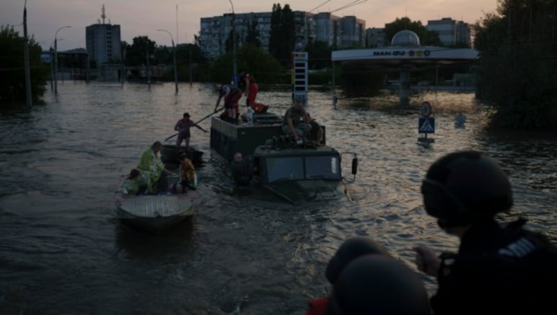 Bewohner versuchen verzweifelt, sich aus den Wassermassen zu retten. (Bild: ASSOCIATED PRESS)