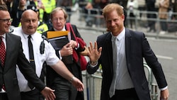 Prinz Harry winkt den verhassten Fotografen und lächelt ihnen zu. (Bild: APA/AFP/Adrian DENNIS)