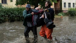 Cherson: Rettungskräfte bringen einen Evakuierten in Sicherheit, der unter Beschuss der russischen Streitkräfte geraten war. (Bild: The Associated Press)