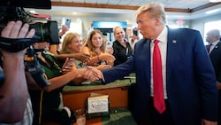 Der ehemalige US-Präsident Donald Trump mit seinen Fans nach einem Gerichtstermin in Miami (Bild: AP)