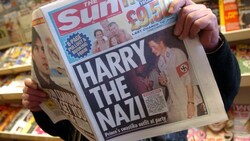 Ein Mann liest im Jänner 2005 die Zeitung „Sun“, die ein Bild von Prinz Harry auf einer Kostümparty am Cover hat. (Bild: Kay Nietfeld / EPA / picturedesk.com)