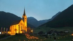 Die Wiese vor der Kirche sowie Balkone und Fenster in Kartitsch leuchten in der Nacht auf Sonntag durch Flammen und durch elektrische Lichtpunkte. (Bild: Gemeinde Kartitsch)