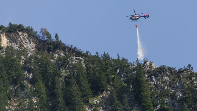 Der Waldbrand wird mithilfe von Helikoptern gelöscht.